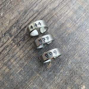 May include: Three silver rings with the numbers 444, 777, and 999 engraved on them.