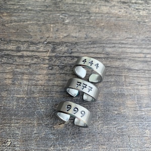 May include: Four silver rings with the numbers 444, 777, and 999 engraved on them.