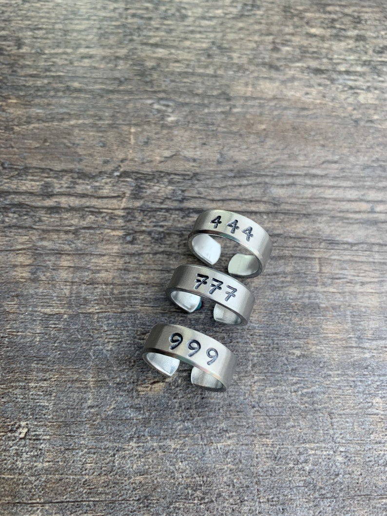 May include: Four silver rings with the numbers 444, 777, and 999 engraved on them.