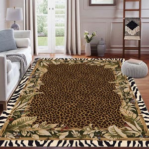 May include: A rectangular area rug with a leopard print center, framed by a border of green leaves and tan accents. The outer edge features a zebra stripe pattern. The rug is placed on a hardwood floor.