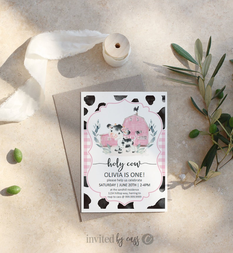 May include: A pink and black cow-print invitation with a pink and white gingham border. The invitation features a cartoon cow in front of a red barn with a black rooster on top. The text reads "holy cow Olivia is one! please help us celebrate SATURDAY | JUNE 20TH | 2-4PM at the sandhill residence 1234 hilltop way, herring tn rsvp to cass @ 999.999.9999 invited by cass".