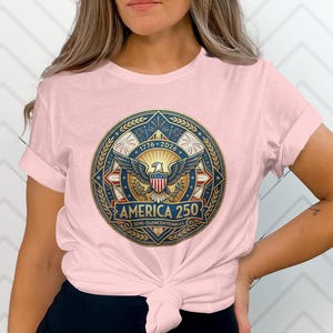 Pink t-shirt with "America 250" emblem celebrating 1776-2026.