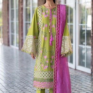 Peut inclure: Une tunique brodée vert citron et un pantalon assorti avec un dupatta rose. La tunique présente des motifs floraux et des détails en dentelle sur les manches. Le dupatta est rose vif avec une bordure décorative. L'ensemble est de style traditionnel.