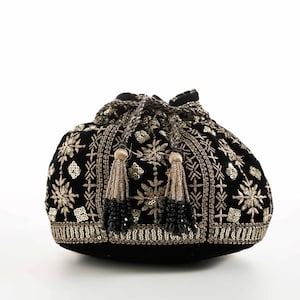 Könnte beinhalten: Ein schwarzer Samtbeutel mit Kordelzug, verziert mit aufwendigen Goldstickereien und floralen Mustern aus metallischen Pailletten. Die Tasche wird mit zwei geflochtenen Kordeln verschlossen, die in dekorativen Quasten aus Goldfäden und schwarzen Perlen enden.