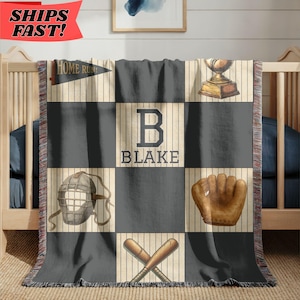 May include: A woven throw blanket featuring a baseball theme with a grid pattern of dark gray and pinstriped squares. The design includes a trophy, a catcher's mask, a baseball glove, crossed bats, a pennant reading HOME RUN, and the letter B with BLAKE.