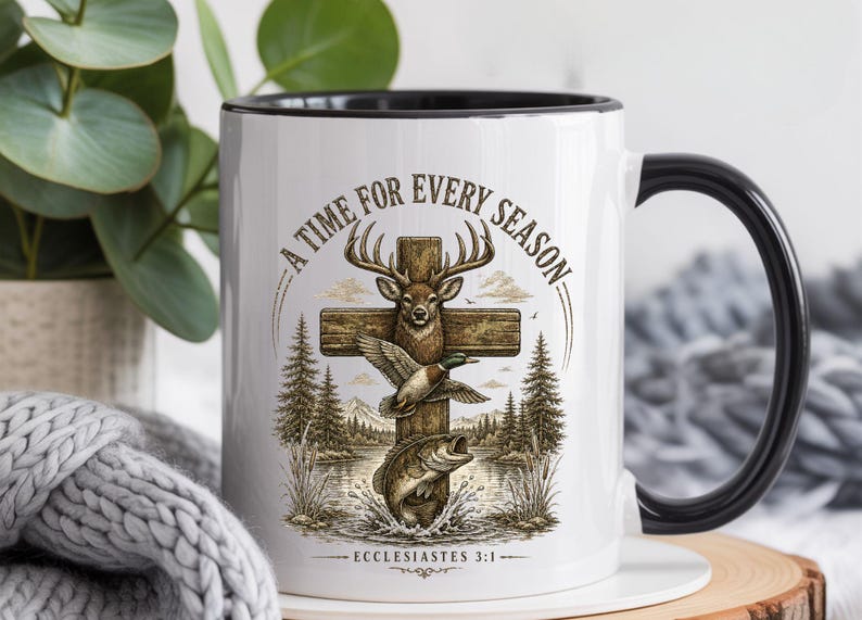 K&ouml;nnte beinhalten: Ein wei&szlig;er Keramikbecher mit schwarzem Henkel und Rand, verziert mit einer Grafik aus einem Holzkreuz, einem Hirsch, einer Ente und einem Fisch. Der Text A TIME FOR EVERY SEASON steht dar&uuml;ber und ECCLESIASTES 3:1 ist unter dem Motiv abgedruckt.