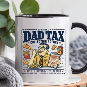 May include: White ceramic mug with a black interior and handle. The mug features a graphic of a man eating fries, with the text "OFFICIAL DAD TAX COLLECTION AGENCY" and "IF I'M BUYING, I'M TRYING".