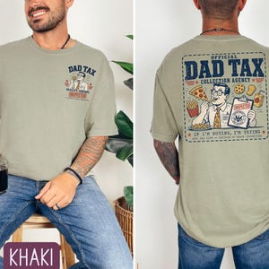 May include: Khaki-colored t-shirt with "DAD TAX" graphic on the front and back. The front graphic features a cartoon man with the text "QUALITY CONTROL INSPECTOR." The back graphic reads "OFFICIAL DAD TAX COLLECTION AGENCY."