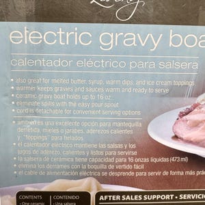 K&ouml;nnte beinhalten: Eine Verpackung f&uuml;r eine elektrische Sauciere mit dem Text electric gravy boat und calentador el&eacute;ctrico para salsera. Die Box nennt Merkmale wie ein Fassungsverm&ouml;gen von 473 ml, einen Ausgie&szlig;er und ein abnehmbares Kabel zum Servieren.