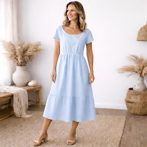Peut inclure: Robe midi bleu clair &agrave; manches courtes et col rond. La robe pr&eacute;sente un corsage ajust&eacute; et une jupe &agrave; volants. Le mod&egrave;le porte des sandales dor&eacute;es. La robe est en tissu l&eacute;ger.