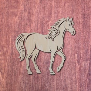 May include: A light brown wooden horse cutout, depicted in a walking stance. The horse features detailed cut lines for the mane, tail, and body. The background is a reddish-brown wood grain.