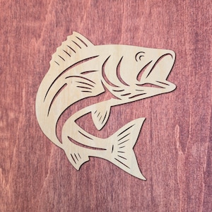 May include: A light-coloured, flat wooden cutout of a fish in a leaping position. The design features stylised, open-cut lines that define the fish's body, fins, tail, and open mouth, creating a silhouette effect with a smooth, natural wood grain finish.