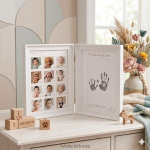Peut inclure: Un présentoir photo de bébé blanc avec 12 petites fentes pour photos et un cadre pour empreintes de mains. Le cadre de gauche contient des photos de bébé. Le cadre de droite contient des empreintes de mains et le texte "Made with Love". Des blocs de bois épellent "1 an de croissance".