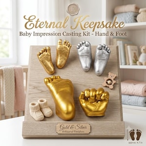 May include: A light wood display board featuring the text Eternal Keepsake Baby Impression Casting Kit - Hand & Foot. It includes gold and silver baby foot and hand casts, a small wooden bear rattle, and tiny beige knit booties. A label reads Gold & Silver Artisanal Finishes, with a 4.7 inch scale reference.