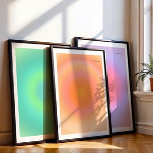 Puede incluir: Tres impresiones art&iacute;sticas enmarcadas apoyadas contra una pared. Las impresiones presentan dise&ntilde;os de gradiente coloridos en tonos verdes, naranjas y morados. El texto "dream bigger thoughts" es visible en las impresiones. Los marcos son negros.