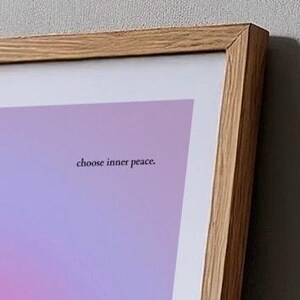 Puede incluir: Una impresi&oacute;n art&iacute;stica enmarcada con un fondo degradado de tonos rosas, morados y azules. El texto "choose inner peace" se muestra en una fuente peque&ntilde;a y centrada. El marco es de madera clara.