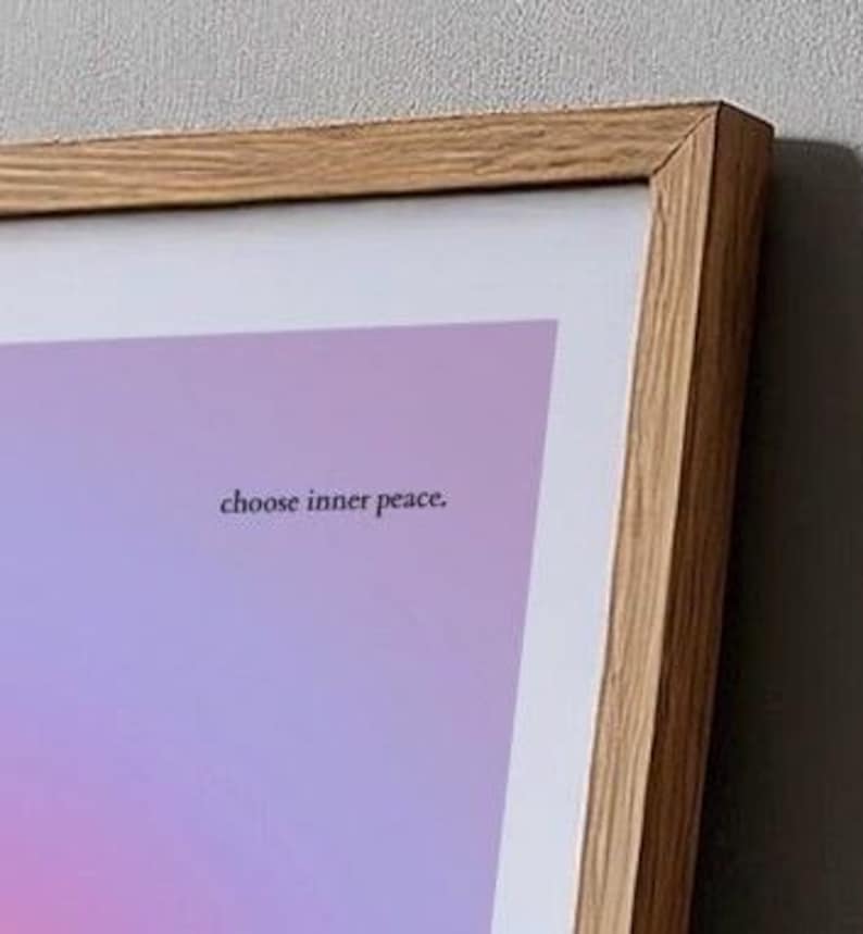 Puede incluir: Una impresi&oacute;n art&iacute;stica enmarcada con un fondo degradado de tonos rosas, morados y azules. El texto "choose inner peace" se muestra en una fuente peque&ntilde;a y centrada. El marco es de madera clara.