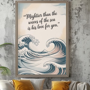 May include: A framed art print depicting stylized ocean waves in blue and white, with the quote, "Mightier than the waves of the sea is his love for you," in black text. The print hangs above a white sofa with yellow cushions, creating a calming aesthetic.