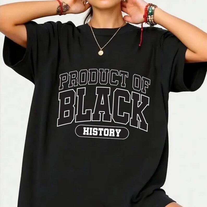 May include: Black t-shirt with the text "PRODUCT OF BLACK HISTORY" in a white, collegiate-style font. The shirt has short sleeves and a relaxed fit, suitable for casual wear. The design is centered on the front of the shirt.