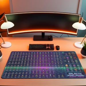 May include: A desk setup featuring a large curved monitor, keyboard, and mouse. A large rectangular mousepad with a blue and purple design and the text "GALACTIC PIXELPEDIA" is the focal point. Two desk lamps and potted plants flank the monitor.