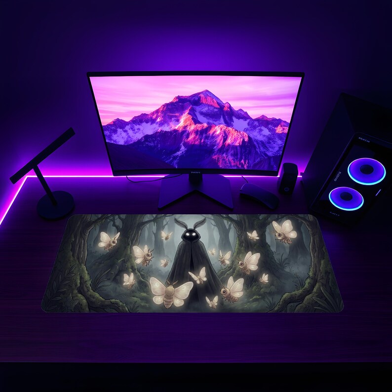 May include: A rectangular mousepad featuring a dark forest scene with a cloaked figure and glowing moths. The artwork is set against a purple-lit desk with a computer monitor, mouse, and keyboard. The computer case has blue lights.