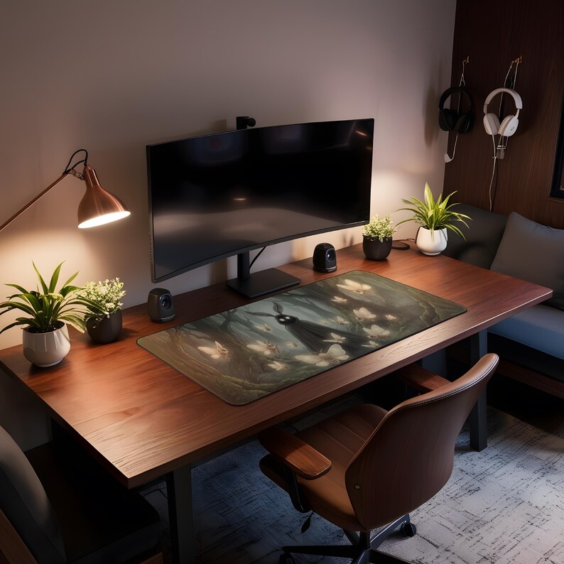 May include: A computer desk with a large monitor, speakers, and a decorative mousepad featuring a forest scene with a dark figure and white butterflies. The desk is made of wood and has a brown leather chair.
