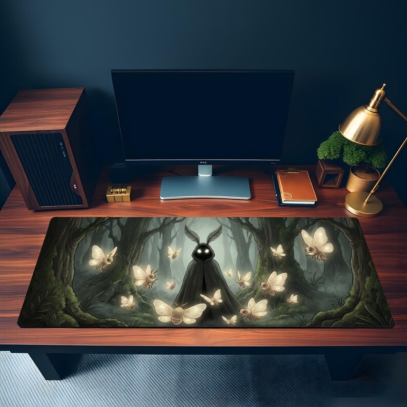 May include: A rectangular desk mat featuring a dark forest scene with a central figure in a black cloak and rabbit-like ears. Numerous glowing moths and trees are visible, creating a mystical atmosphere. The mat is designed to protect the desk surface.