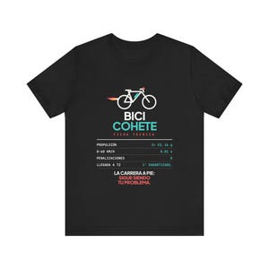 May include: A black t-shirt featuring a white graphic of a bicycle with a rocket flame exhaust. Below the bicycle, the text reads BICI COHETE FICHA TÉCNICA, followed by technical specifications and the phrase LA CARRERA A PIE: SIGUE SIENDO TU PROBLEMA.