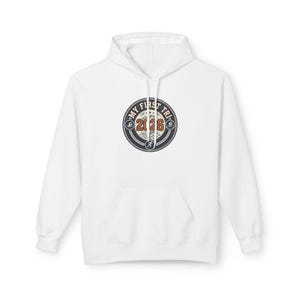 May include: A white hooded sweatshirt featuring a circular graphic on the chest. The design includes the text "MY FIRST TRI" and "2026" in orange, with small icons representing swimming, cycling, and running inside a dark blue and white border.