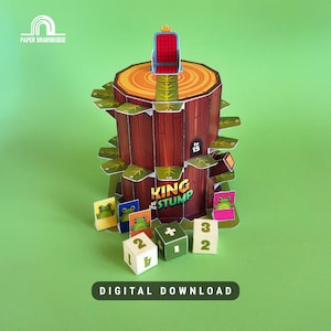 Puede incluir: Un juego de mesa colorido llamado "King of the Stump" con un diseño de tocón de árbol y un pequeño trono rojo. Incluye piezas de juego con temática de rana y dados. El texto "DIGITAL DOWNLOAD" está en la parte inferior.