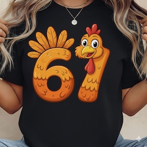 May include: Black t-shirt featuring a cartoon turkey design with the numbers 61 in orange. The number 6 has a feather design, and the number 1 is a turkey head. The turkey has a red wattle and a yellow beak.