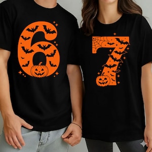 May include: Black t-shirts with orange Halloween-themed designs. One shirt features the number 6 filled with bats and a jack-o'-lantern. The other shirt displays the number 7 with bats, a spiderweb, and a jack-o'-lantern. Both shirts have star accents.