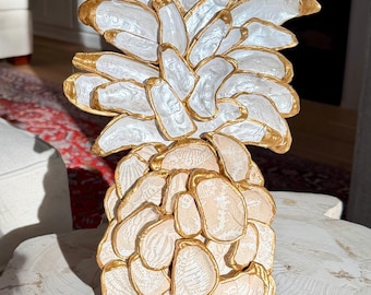 Escultura de piña ostra beige de gran tamaño en la playa