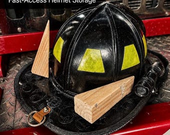 May include: A black firefighter helmet with yellow accents and a leather brim, accompanied by wooden wedges and a flashlight. The text "Magnetic Wedge Kit" and "Fast-Access Helmet Storage" are displayed above the helmet.
