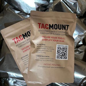 May include: Two tan paper pouches labeled TACMOUNT, an adjustable MOLLE system for firefighter bunker coats. The text reads: SECURE YOUR TOOLS. SIMPLIFY YOUR GEAR. IN THIS BAG: MOLLE rail, tool pouch, 2 wedge holders, tool holder, rectangular D-ring, and MOLLE D-ring. Includes a QR code.