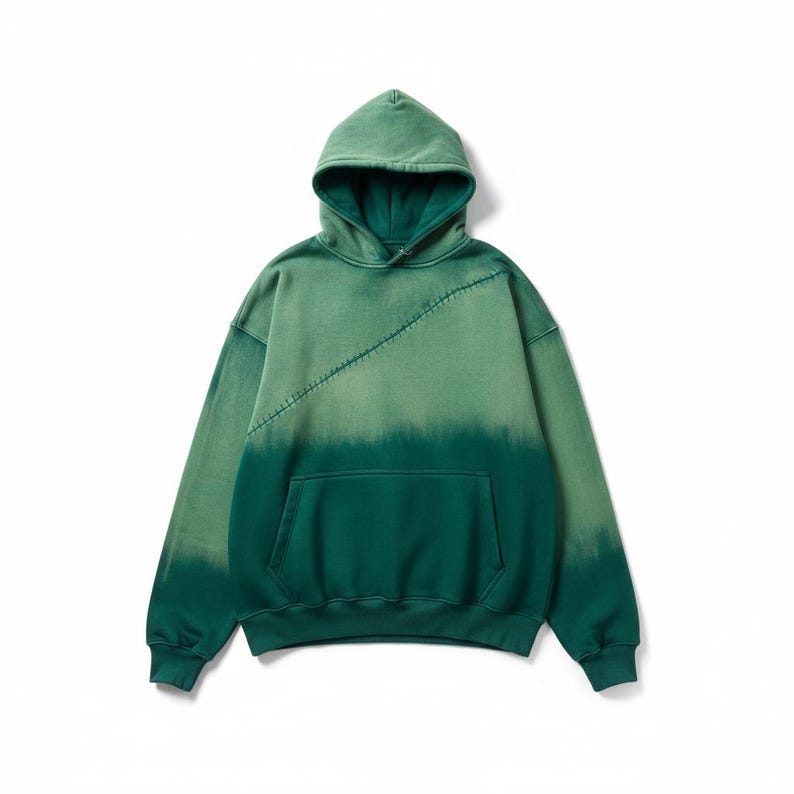 Puede incluir: Sudadera con capucha verde con efecto degradado de color. La mitad superior es de un verde m&aacute;s claro, que pasa a un verde m&aacute;s oscuro en la parte inferior. Cuenta con capucha, mangas largas y un bolsillo delantero. Una costura diagonal a&ntilde;ade un toque &uacute;nico.