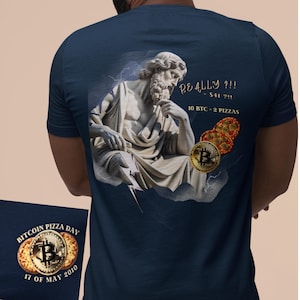 Puede incluir: Camiseta azul marino con un gráfico de una estatua y el texto "REALLY?!!" y "10 BTC - 2 PIZZAS". La camiseta también tiene un gráfico del Día de la Pizza Bitcoin con la fecha "17 DE MAYO DE 2010".