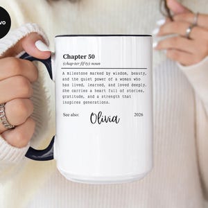 May include: White ceramic mug with a black rim and handle, featuring text that reads "Chapter 50" and a definition. The mug also includes the name "Olivia" and the year "2026".