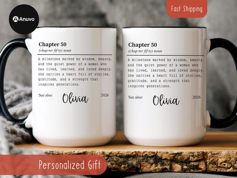 May include: Two white ceramic mugs with black handles and rims. Each mug features the text "Chapter 50" and a definition, along with the name "Olivia" and the year "2026". The mugs are personalized gifts.