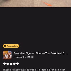 May include: Four small, hand-painted character figures arranged on a white surface. The figures include a light green and tan creature, a blue aquatic creature, an orange fire-breathing creature, and a yellow creature with black-tipped ears.