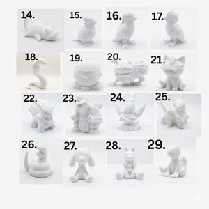 May include: A collection of sixteen small, white, matte-finished figurines arranged in a grid, each labeled with a number from 14 to 29. The figures depict various stylized creatures with distinct shapes, including birds, snakes, and other fantasy-inspired forms.