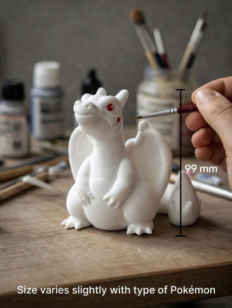 May include: A white dragon-like creature figurine with red eyes and red cheek spots. A vertical line indicates a height of 99 mm. The text at the bottom reads: Size varies slightly with type of Pok&eacute;mon. The figurine has wings and a tail.