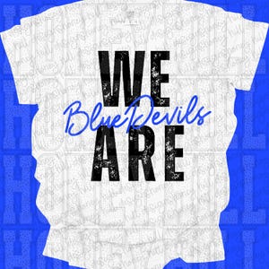 May include: White t-shirt with the text "WE ARE Blue Devils" in black and blue. The words "WE ARE" are in a bold, distressed font, while "Blue Devils" is in a cursive script.