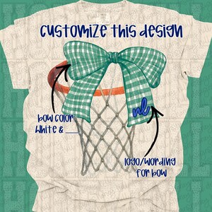Puede incluir: Camiseta color crema con un diseño de canasta de baloncesto con un lazo a cuadros verde y blanco. El texto "Customize this design" es azul marino. El diseño incluye espacio para un logotipo o texto.