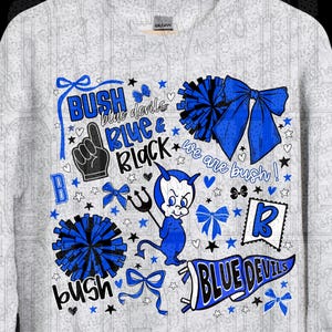 May include: A light gray sweatshirt with a graphic design featuring the words "BUSH blue devils BLUE & BLACK" in blue and black. The design includes a devil character, bows, stars, and the text "we are bush!"