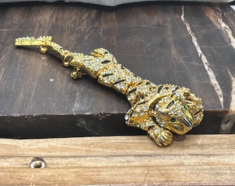 Broche articulado de tigre en tono dorado, diamantes de imitación pavé, rayas de esmalte negro, ojos de esmeralda.