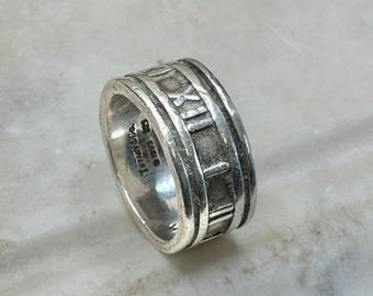 Anillo Atlas de Tiffany & Co., banda de plata de ley con números romanos, talla 10.5, banda ancha para hombre, sello 925, 12.94 gramos.