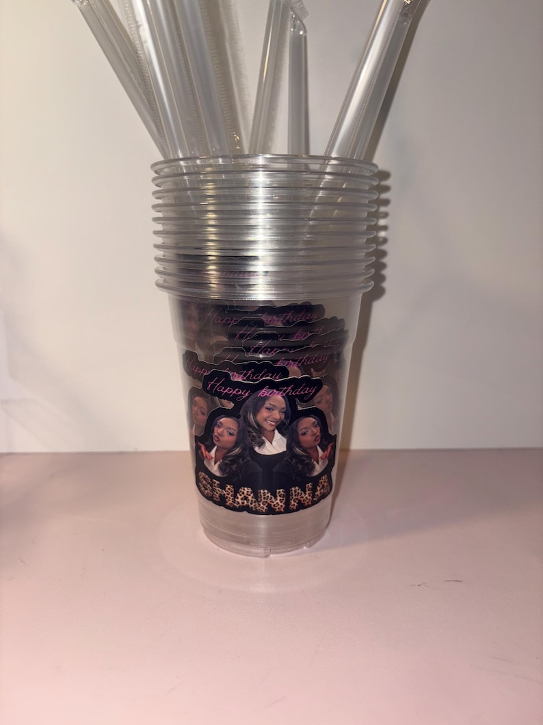 May include: Clear plastic cups stacked with clear straws. The cups have a personalized design with the text "Happy Birthday" and the name "Shanna". The design features multiple images of a woman.