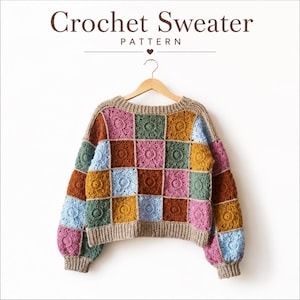 May include: A crochet sweater pattern featuring a multi-colored patchwork design of square motifs in shades of pink, green, blue, and mustard yellow. The sweater has a beige ribbed neckline, cuffs, and hem, and is displayed on a wooden hanger.