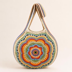 May include: A round crochet bag featuring a vibrant, multi-colored floral pattern in shades of orange, yellow, green, blue, and purple. The bag has a single integrated shoulder strap and a central circular motif, all crafted with intricate yarn stitching.